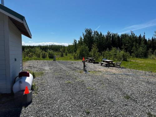 a gravel area with picnic tables and a building at RV Site (Full Hookups) in Sterling