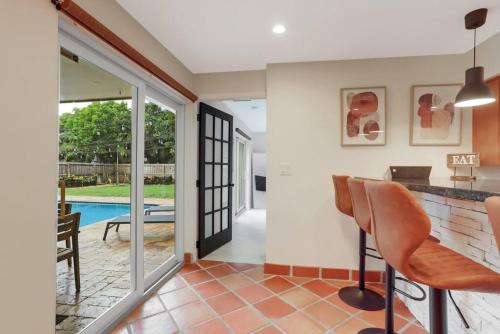 a home with a pool and a kitchen with chairs at 3BR HEATED POOL CLOSE TO BEACH in Boynton Beach