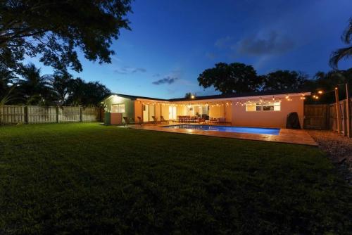 a backyard of a house with a swimming pool at night at 3BR HEATED POOL CLOSE TO BEACH in Boynton Beach