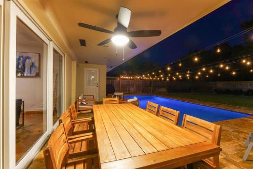 a patio with a wooden table and a ceiling fan at 3BR HEATED POOL CLOSE TO BEACH in Boynton Beach