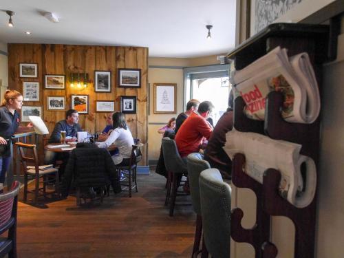 a group of people sitting at tables in a restaurant at The Fox in Chipping Norton