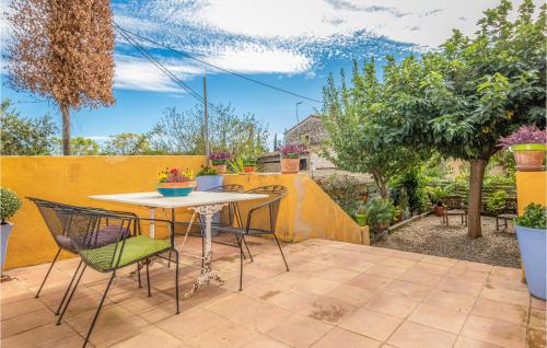 a patio with a table and chairs in a backyard at Lovely Home In Vilademuls With Wifi in Vilademuls