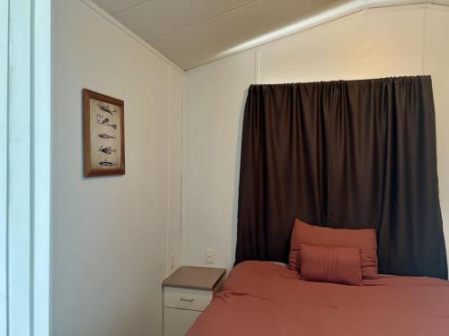 una camera da letto con un letto con un cuscino rosa e una finestra di Trout House at Red-Bow a Sterling