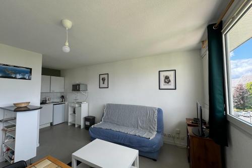 un salon avec un canapé bleu et une cuisine dans l'établissement Nice T2 in the heart of Caen, à Caen