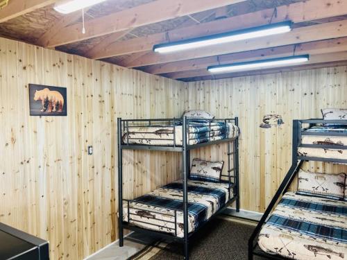due letti a castello in una stanza con pareti in legno di Grayling Bunkhouse at Red-Bow a Sterling