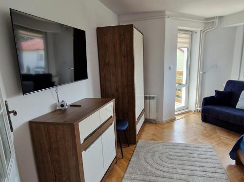 a living room with a dresser and a tv on a wall at Little Wish in Gdańsk
