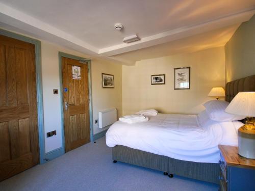 a bedroom with a large bed and a wooden door at The Fox in Chipping Norton