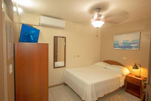 a bedroom with a bed and a dresser with a mirror at Hotel Laura's House in Coco