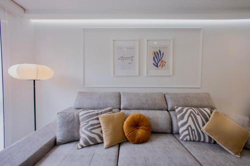a living room with a gray couch with pillows at Rosalia Park by Lugo Collection in Lugo