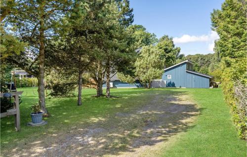 a path leading to a blue barn and trees at Two-Bedroom Holiday Home In Rudkobing in Spodsbjerg