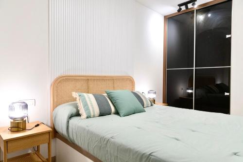 a bedroom with a bed and a night stand with a lamp at Rosalia Park by Lugo Collection in Lugo