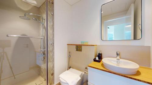 a bathroom with a sink and a shower and a mirror at Vacationer Holiday Homes I Modern 1 Bedroom I Peaceful Location I Near Dubai Hills Mall & Park in Dubai