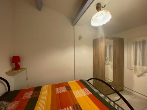 - une chambre avec un lit et une couverture colorée dans l'établissement Charmant T2 avec Terrasse, Clim, Parking et Wifi - FR-1-503-155, à Balaruc-les-Bains