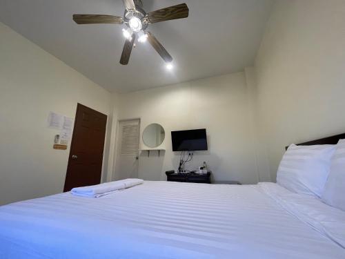 a bedroom with a white bed with a ceiling fan at เวลาและนาที Wella&Natee in Chiang Khan
