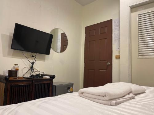 a bedroom with a bed with a flat screen tv at เวลาและนาที Wella&Natee in Chiang Khan