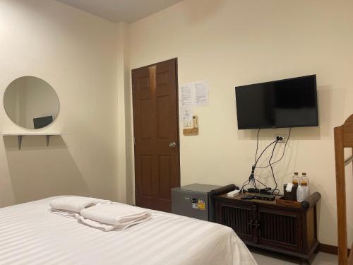 a bedroom with a bed and a flat screen tv at เวลาและนาที Wella&Natee in Chiang Khan
