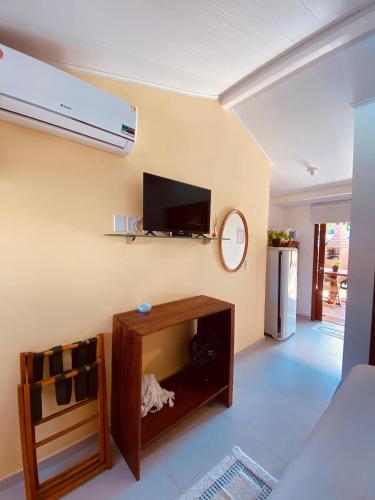 a living room with a flat screen tv on the wall at Pontal dos Sonhos- Chalés Praia do Farol in Coruripe