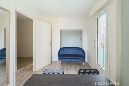 Cette chambre dispose d'une chaise bleue et d'une fenêtre. dans l'établissement Flexliving - room - Croix Nivert, à Paris