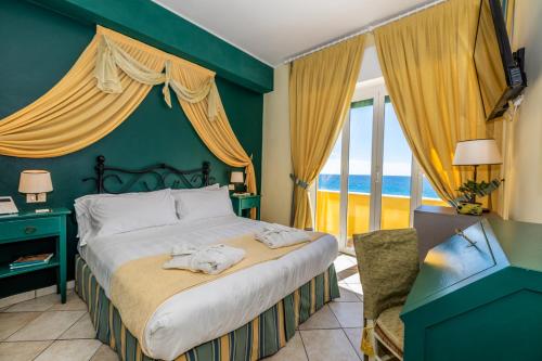 a bedroom with a bed with a view of the ocean at Hotel Albatros Varigotti in Varigotti