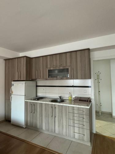 eine Küche mit Holzschränken und einem weißen Kühlschrank in der Unterkunft Aleksandra in Ohrid