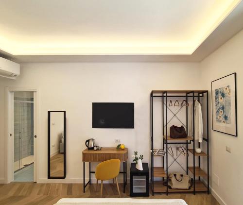 Cette chambre comprend un bureau et une télévision murale. dans l'établissement Nellerika Sorrento - Ametista Holidayhome, à Sorrente