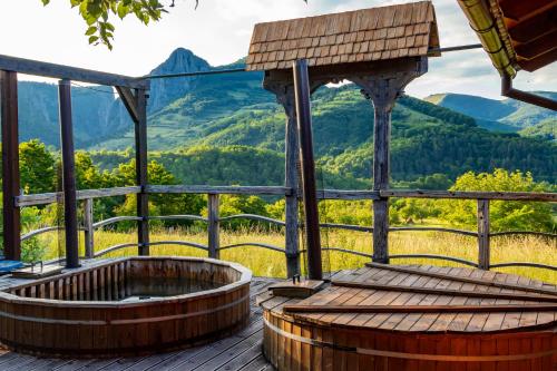 a hot tub on a deck with a view of mountains at Popas 8 Odăi in Poiana Aiudului