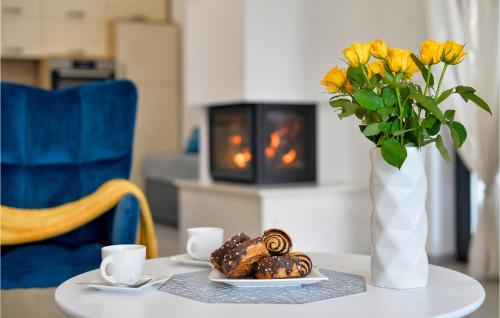 a table with a vase of yellow flowers and pastries at Pet Friendly Home In Vinica Breg in Gorušenjak