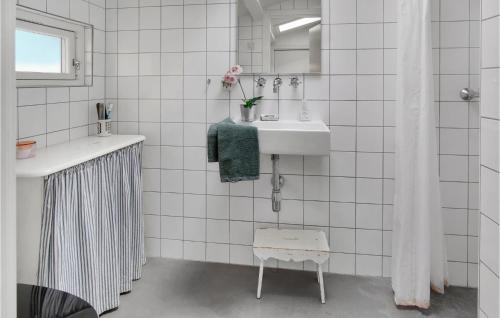 a white tiled bathroom with a sink and a mirror at Amazing Home In Rørvig With Kitchen in Rørvig