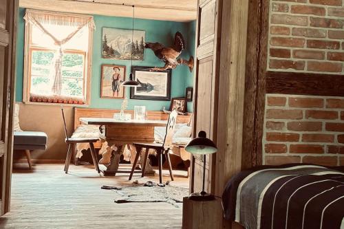 a room with a desk and a table with a bird on the wall at Auszeit auf dem Land im Forsthaus Hohe Heide in Heiligengrabe