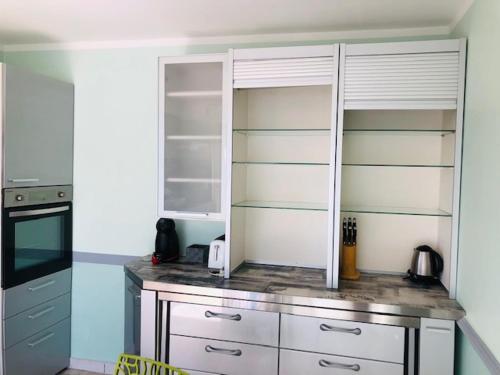 a kitchen with white cabinets and a counter top at Résidence Villa Nova in Tiuccia