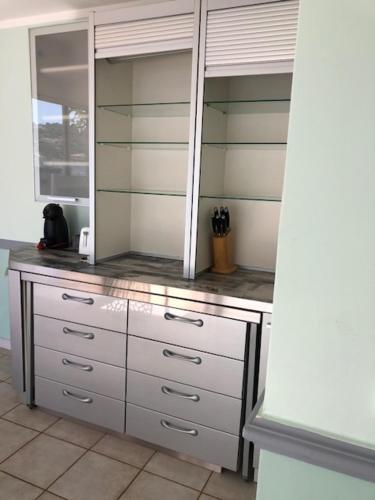 a kitchen with a counter with white cabinets and a window at Résidence Villa Nova in Tiuccia