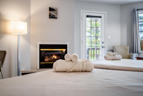 a room with two beds with towels and a fireplace at Muskoka Waterfront Retreat in Dwight