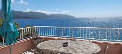 a table on a balcony with a view of the ocean at Résidence Villa Nova in Tiuccia