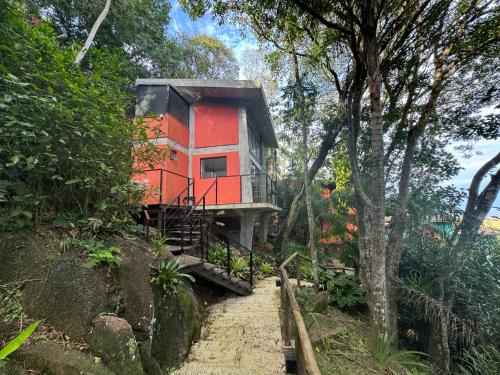 a house on the side of a hill with trees at Casas Temporada Aldeia Niura Opy in Florianópolis