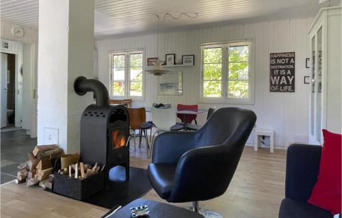un salon avec une chaise et une cheminée dans l'établissement 3 Bedroom Awesome Home In Nexø, à Strandby Gårde