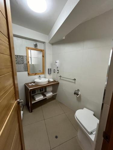 a bathroom with a sink and a toilet and a mirror at CASA CRISTOBAL Centenario in Cusco