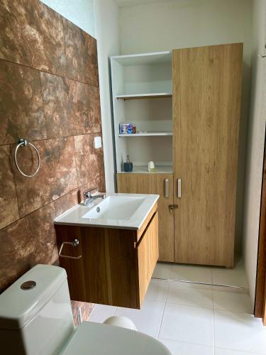 a bathroom with a white toilet and a sink at Roma apartamento in Playa Blanca