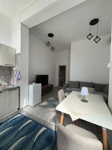 una sala de estar con una mesa y un sofá en Apartman sm, en Herceg-Novi