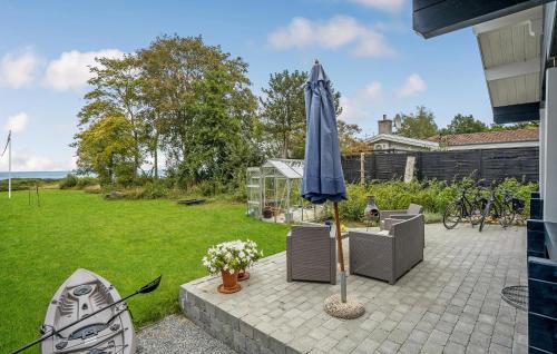 a blue umbrella sitting on a patio with a yard at Awesome Home In Kalundborg With Wifi in Kalundborg