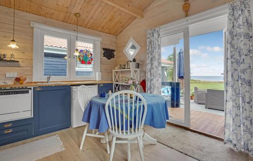 a kitchen with a table and chairs and a kitchen with blue cabinets at Awesome Home In Kalundborg With Wifi in Kalundborg