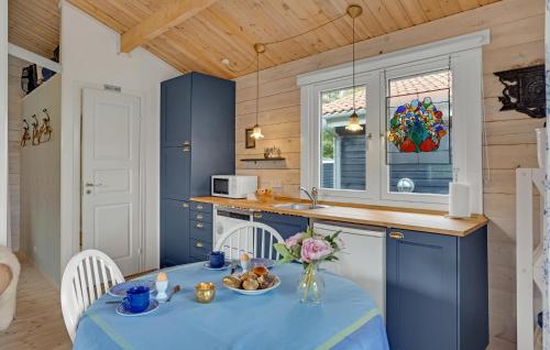 a kitchen with blue cabinets and a table with food on it at Awesome Home In Kalundborg With Wifi in Kalundborg