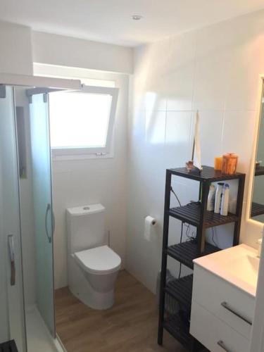 a small bathroom with a toilet and a shelf at Apartamento nuevo Playa aislada Primera línea de playa in Cullera