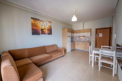 a living room with a couch and a table and a kitchen at Franklin Rooms in Sarandë