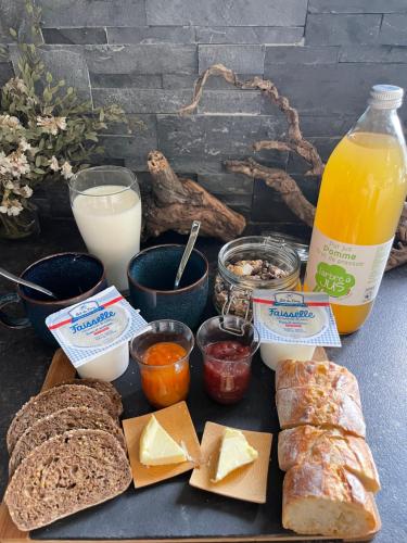 MontverdunにあるTente bohème - Ô Sens en Eveilのパンとチーズと牛乳のボトルが置かれたテーブル