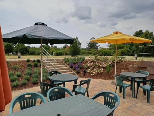 two tables and chairs with umbrellas on a patio at Centrum Mariapoli in Prague