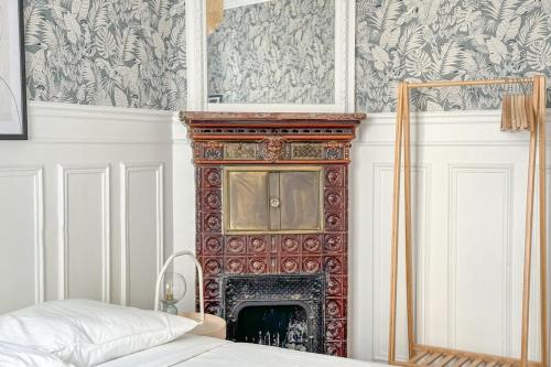 Cette chambre dispose d'une cheminée et d'un lit en face. dans l'établissement Flexliving - room - Hameau, à Paris