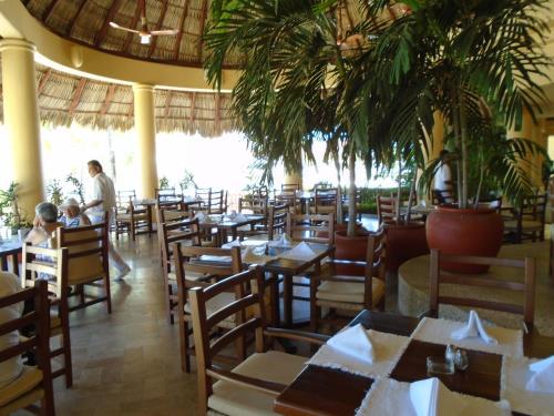 a restaurant with tables and chairs with people sitting at them at Villa Marina Porto Ixtapa in the Private Yacht Club in Ixtapa