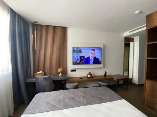 a hotel room with a bed and a tv on the wall at Executive Boutique Hotel Rabat in Rabat