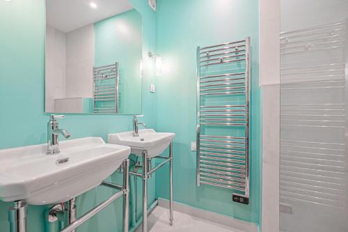 une salle de bain avec deux lavabos et un miroir dans l'établissement Moderne Paris Centre 2 chambres, à Paris
