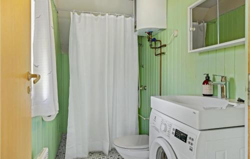 a bathroom with a white sink and a washing machine at Gorgeous Home In Nexø With Kitchen in Neksø
